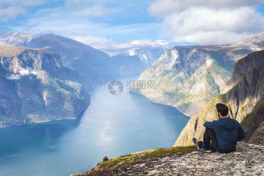 独自坐在悬崖边享受鸟瞰背包生活方式旅行冒险户外暑假在挪威美丽的山顶蓝天徒步旅行者独自坐在悬崖边享受鸟瞰背包生活方式旅行冒险户外暑图片