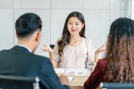 年轻亚洲女毕业生与两名经理面谈在会议室企业雇用新会员工作面试经理概念等积极动议下对两名经理进行访谈商业聘用新成员合同信心人们背景图片