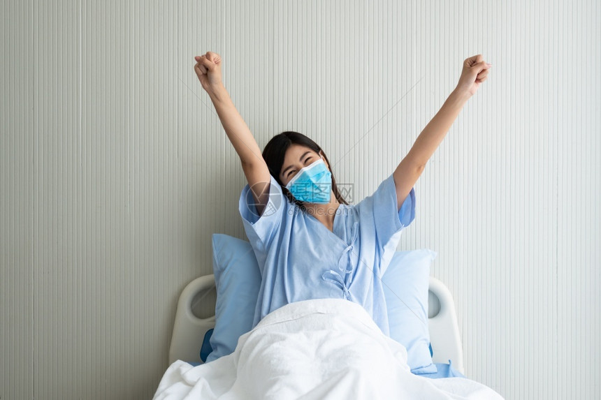 戴口罩躺在病床上乐观的女病人图片