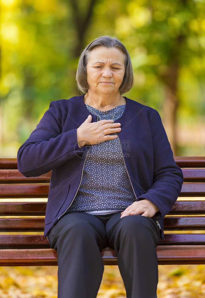 在秋天公园的上身露出心肌梗痛或短脏病发作时将胸口紧抓在疼痛中的高级女士健康梗塞心绞痛图片