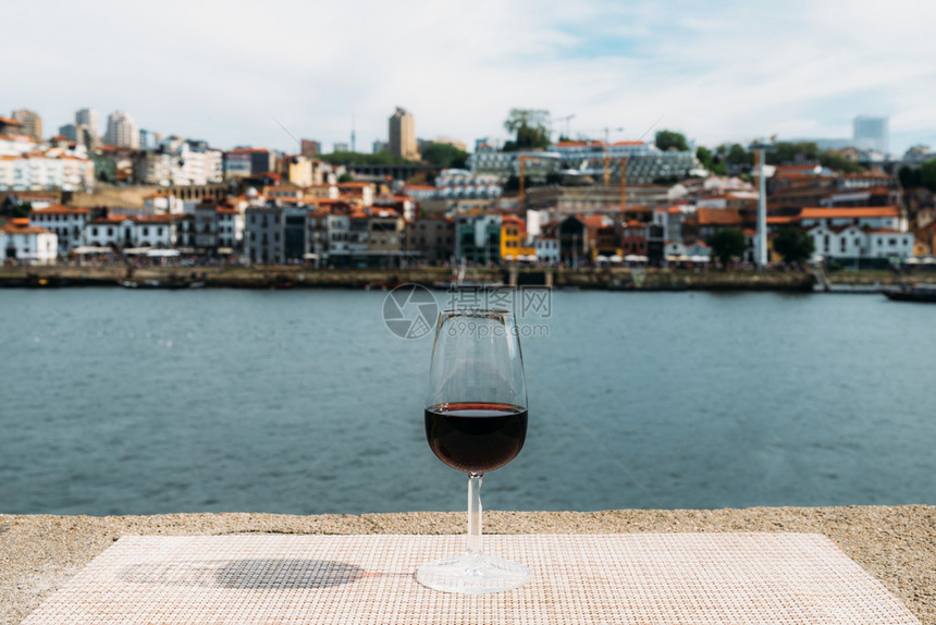 北对称葡萄牙语在波尔图杜罗河上的CaisdaRibeira俯瞰VilaNovadeGaia堤岸的小杯红葡萄酒选择焦点俯瞰葡萄牙波图片