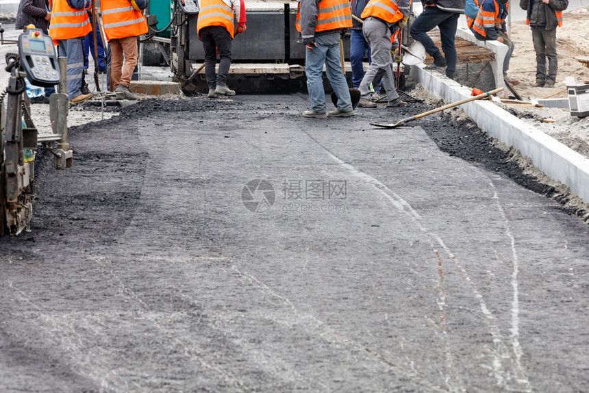 活动公路工人作组以新的热沥青更道路干线并用新鲜的热沥青平滑地修补道路面复制空间一个道路工人作组平均分配第一层热沥青在道路段上人工图片