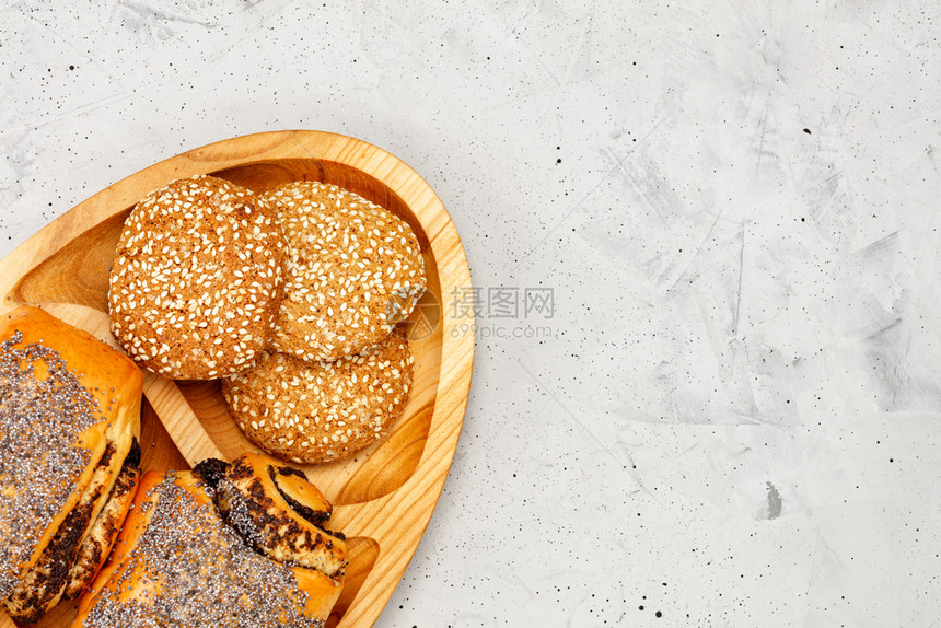 最佳木制厨房板上装有籽和芝麻种子的自制新鲜面包其背景是灰色混凝土特闭复制空间自新鲜面包籽和饼干它位于灰色混凝土背景下的木制厨房板图片