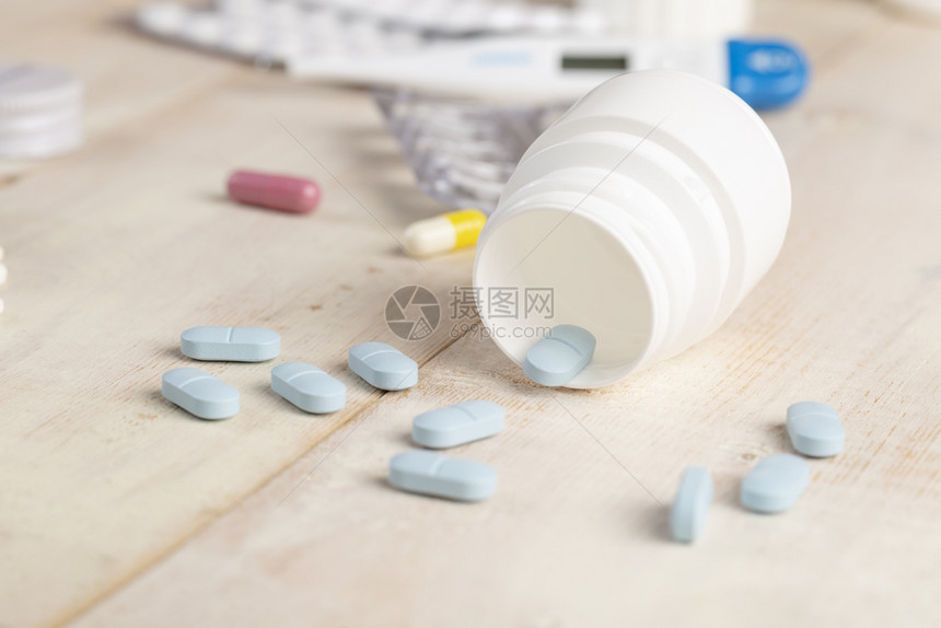 药剂玻璃和塑料瓶药蓝色片和木制桌子上的彩色医用胶囊玻璃和塑料瓶药蓝色片和彩医用胶囊阿司匹林蓝色的图片