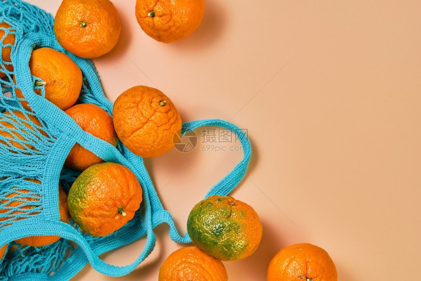 一种健康珊瑚桌上的柑橘果或子水从一个蓝色邮袋板和复制空间散布在桌子对面的普通人团体图片