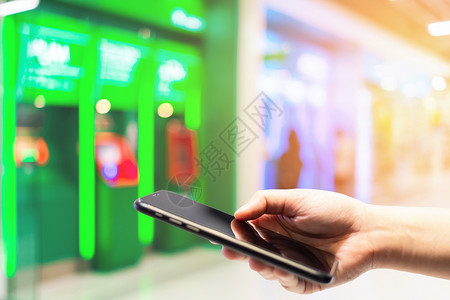 钱途无量移动的抽象银行业手持智能机的模糊图像在新闻部商店用于背景途的蓝色自动取款机图中模糊的摘要图象触摸ATM机器蓝色Blurred背景