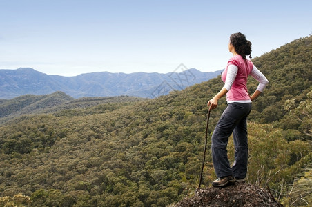顶峰跋涉合身单女远足者在山下看望着风景图片