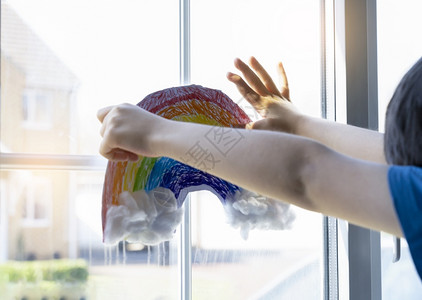 支持棉布在Covid19隔离期间儿童把彩虹涂满鲜艳的和棉毛贴在窗户上的白纸待在家里社交媒体宣传冠状预防概念杰米图片