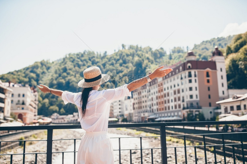 河边吸引人的游客欧洲城市山河堤岸上戴帽子的妇女背影欢乐夏季旅行概念罗莎胡托尔MzymtaRiver索契俄罗斯快乐女孩在一个欧洲城图片