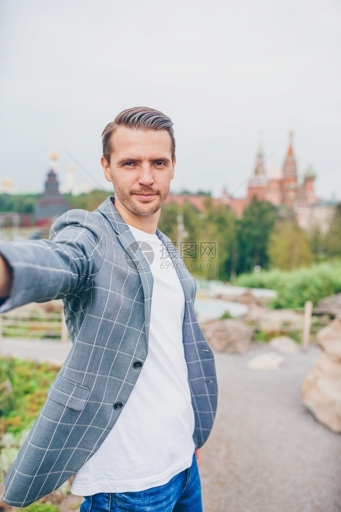放松探险家城市年轻人在莫斯科圣巴西尔教堂背景上自拍户外快乐的城市年轻人享受他在城里的休息沟通图片