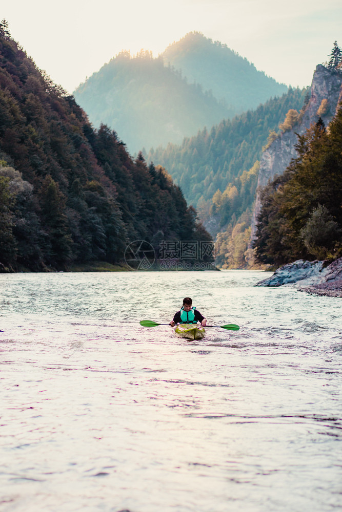 在Dunajec河上骑划艇的年轻男子坐在一条独木舟中在河下游荡享受乘着由山丘环绕和美丽的山谷峰风景环绕的豪华搭乘旅程游流浪湖图片