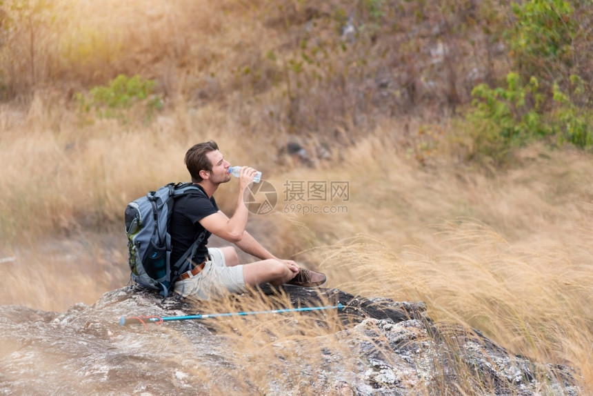 清爽踪迹泰国坐在山顶乡村复制空间的美丽小径上休息的男背包车在乡间复制空的美丽小径上坐着放松图片