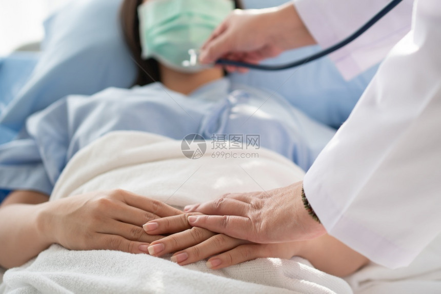 女医生握着病人的手鼓励和提供医疗咨询图片