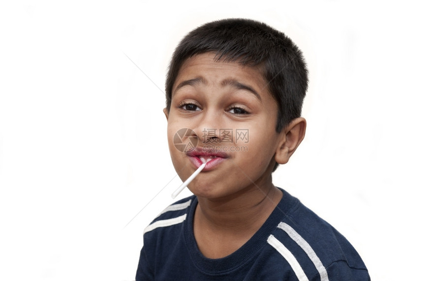 绿色淘气一个英俊的印度孩子有德文和棒糖对待图片
