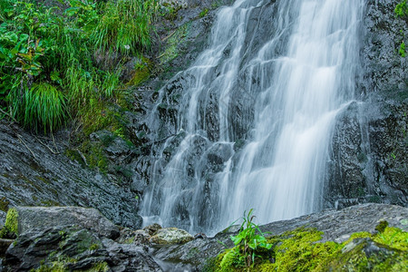 自然生长热带雨林水流中岩石和绿苔之间河流瀑布的大气视图风景图片