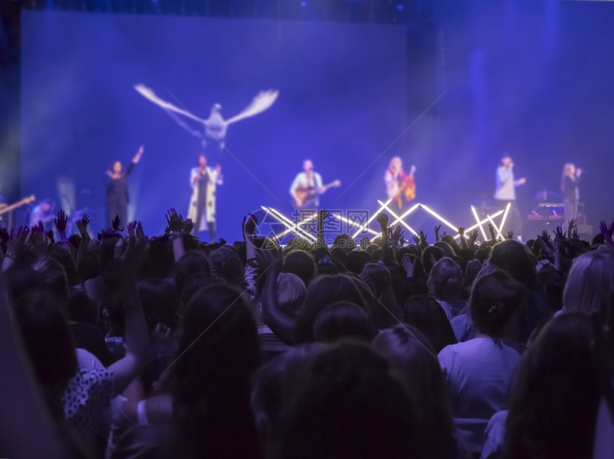 观众用双手在音乐节上举起手来灯光从舞台上下流而多于手指民族图片