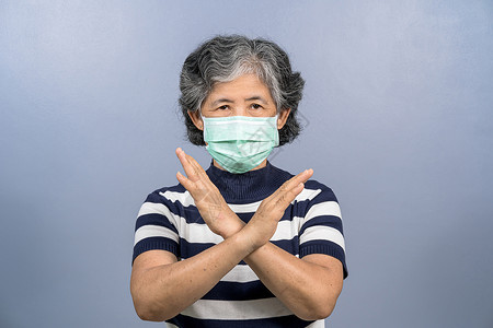 禁止种毒老年蓝色的身戴外科面罩亚洲老妇女肖像不说对蓝色背景共同爆发19年疾病和大流行的冠状毒感染采取行动也不说防止概念呼吸背景