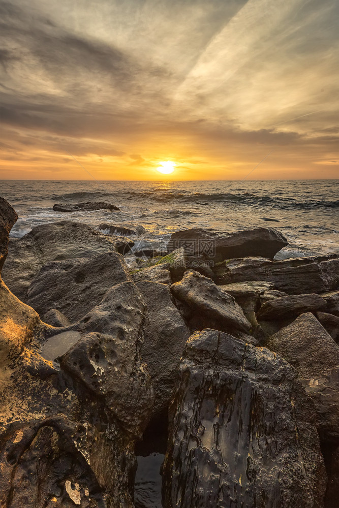 海浪早晨黑色的保加利亚瓦尔纳附近黑海岸的岩石之间闪亮海日出触目惊心图片