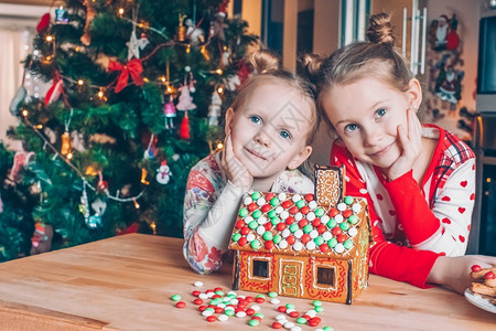 为了小女孩在装饰过的客厅壁炉上制作圣诞姜饼屋活的灯图片