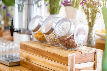 长的玻璃罐在饭店自助餐厅桌边装饰上配有早餐谷物的排可口小吃图片