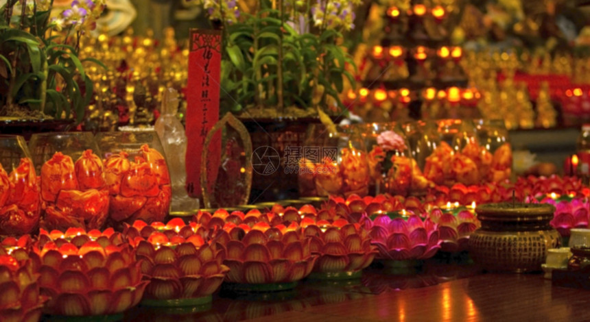 象征佛教寺桌边红蜡烛的模糊形象以在寺庙里恢复生命或导航祈祷优点图片