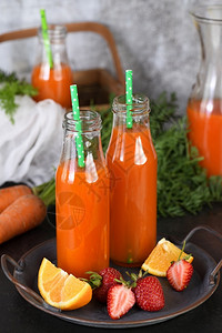 冰沙橙子他们的脱毒饮料新鲜制成胡萝卜草莓橙汁为监测健康的人图片