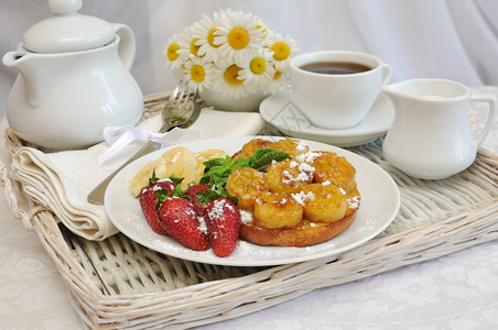 早餐与焦糖香蕉和草莓放在托盘上开胃菜辛辣的津有味图片