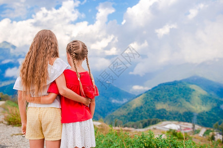 夏天放暑假的小孩美丽快乐小女孩在雾中山上的小姑娘儿们快乐的漂流云图片