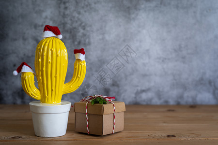 圣诞仙人掌球欢乐新年的装饰品概念化Cactus锅和红色礼品盒用于现代棕褐黄红宝石背景空间设计晚宴季节的红礼盒物件木头结石背景