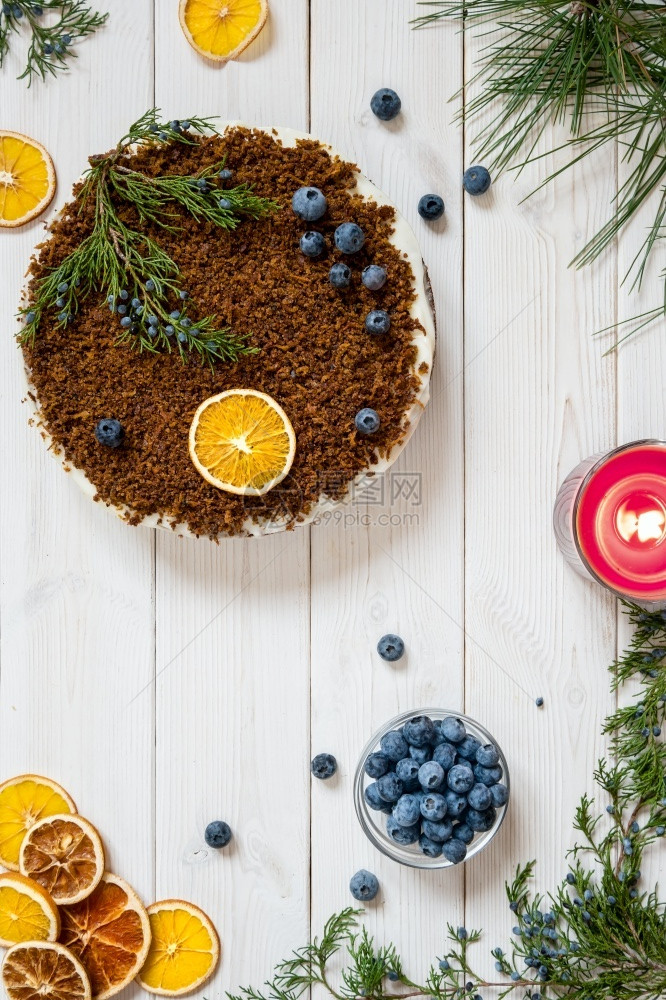 美味的胡萝卜蛋糕和奶油酪在白色木制桌上顶端风景蛋糕装饰用罐头水果蓝莓酱松树和柔美枝蜡烛馅饼仪式图片