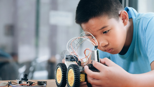 课堂手制汽车模型工作电子集中男孩在实验室制造机器人的建筑工程早期开发暗展创新现代技术概念和新颖在室内能背景图片