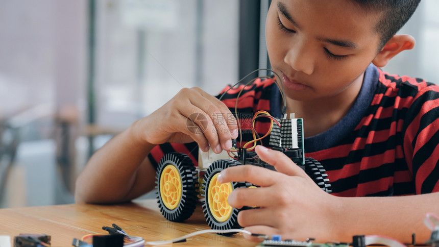 智力创造手制汽车模型工作电子集中男孩在实验室制造机器人的建筑工程早期开发暗展创新现代技术概念和新颖进步图片