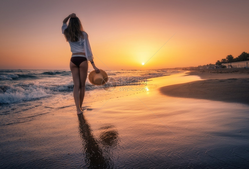 海滩上看夕阳的美女背影图片