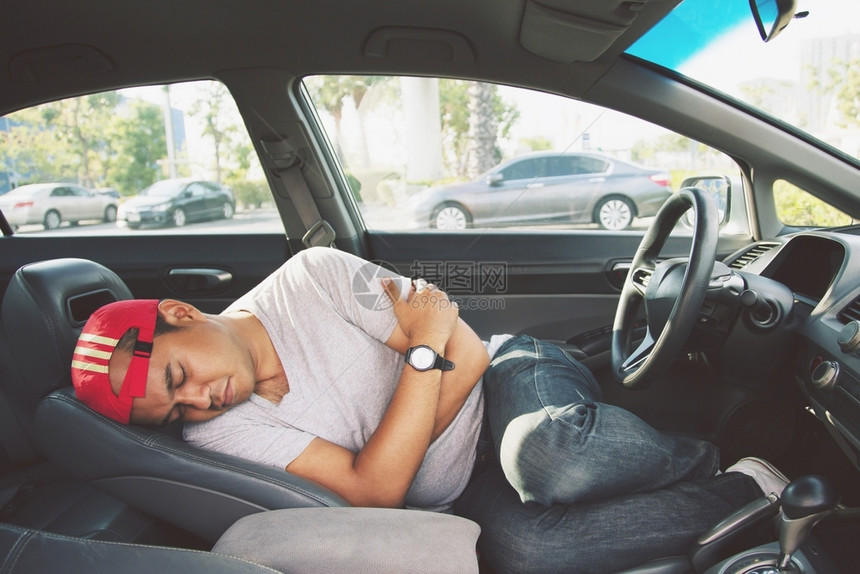 向前疲累的年轻男子驾驶汽车睡在里精疲力尽柬埔寨无法图片