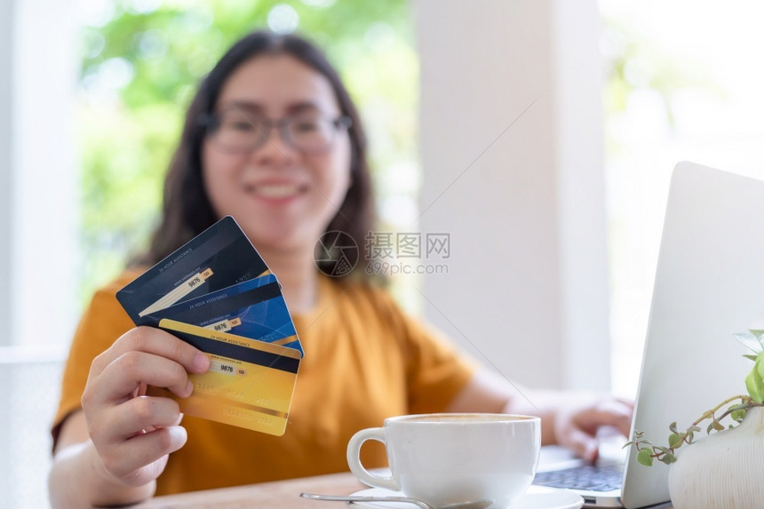 空的银行女自由职业者商余休闲女摘要模糊不清重点为显示持有信用卡在咖啡店笔记本电脑工作如背景在线购物和支付一种图片