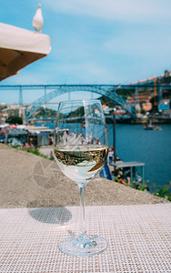 维尼奥罗滕贝格葡萄牙波尔图杜罗河上俯瞰CaisdaRibeira和PontedeDomLuisI的白葡萄酒杯选择焦点玻璃上桥的反射白葡背景