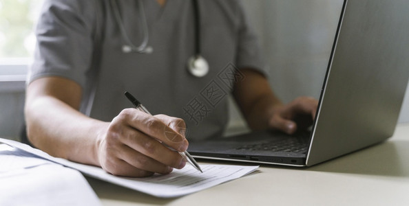 医生侧颜在侧边看医生用听诊器看医生使用笔记本电脑写论文分辨率和高品质的美丽相光侧观察医生用听诊镜看医生用笔记写本电脑文件高质量和分辨率美背景