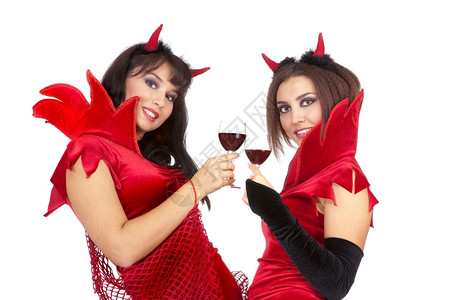 成人两个有魅力的年轻女青穿着万圣节装扮的恶魔缠着红酒杯鬼作品图片