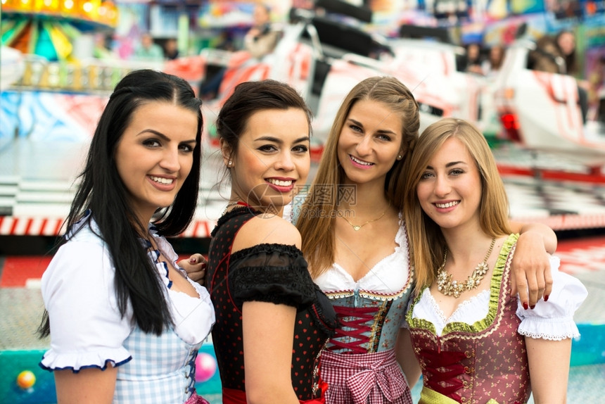 在德国FunfairOktoberfest和传统的dirndl服装和喜乐节上两个非常典型的德语女孩一个是亚裔和高加索混血儿一个是图片