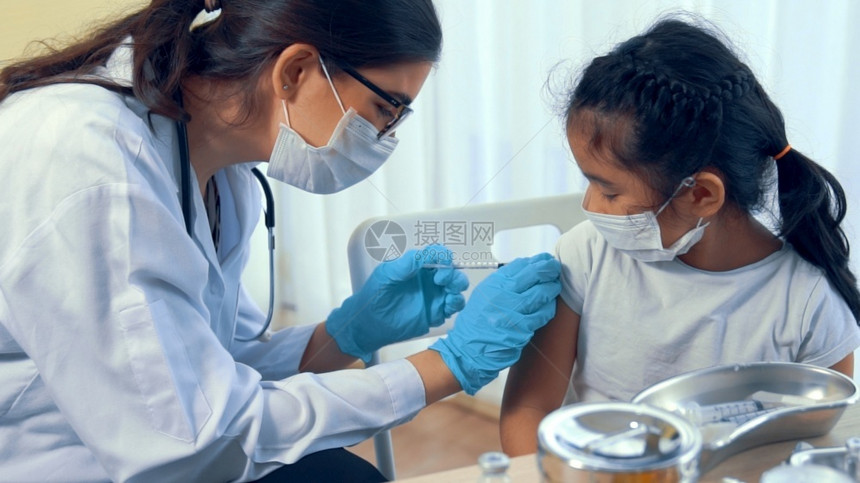 给孩子手臂注射疫苗的医生图片
