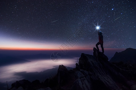 相在他的手中把光照在头顶高处站岩石山峰和银河系上成功胜利获领先导概念高等音象上面是噪领袖男人握住背景图片