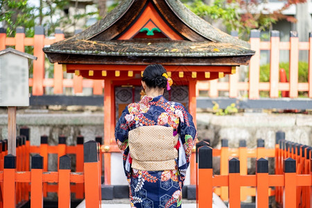 女荷官走道在京都FushimiInari神社红木托里门中身着日本和服的吉沙斯女孩穿日本和服同义词这实际上意味着一件要穿的东西一种女背景