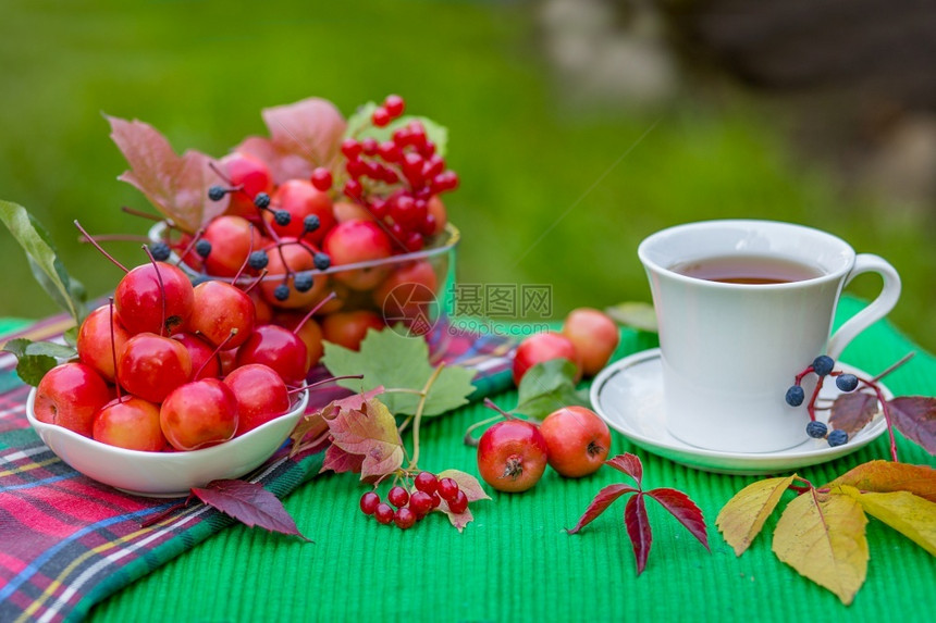 新鲜的餐具甜凉茶配柠檬和天堂苹果在白色木桌上的顶部视图绿色和黄的叶子红苹果花园里的茶柠檬和天堂苹果的凉茶图片