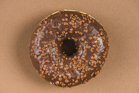 深巧克力甜圈喷洒棕色背景刨冰食物小雨图片
