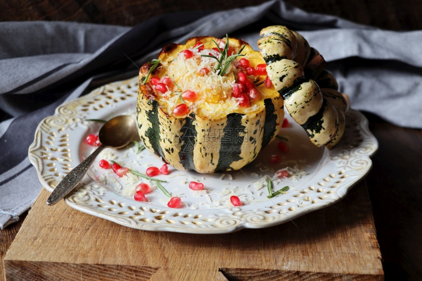 南瓜烩饭放在空心南瓜中烤配奶酪和石榴籽在深色背景上选择焦点里脊肉猪锅图片