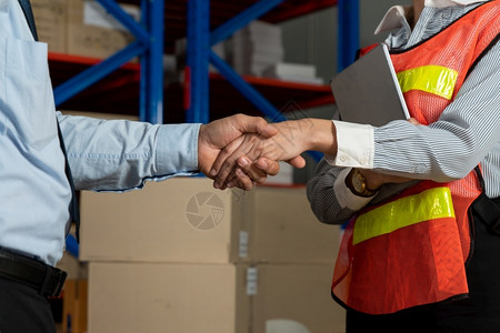 仓储库工人与经理握手物流供应链和仓库业务概念工人与经理握手成功的微笑图片
