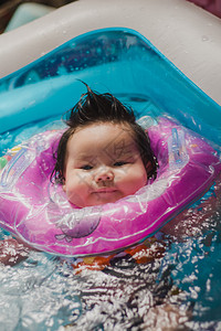 可爱女婴套着泳圈游泳图片