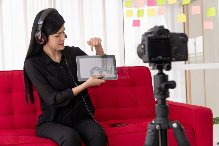 产品教育VlogAsia女博客影响者坐在沙地上并录制视频博客用于教学辅导生或订阅者如何在网上创作新生活方式内容的概念记录图片