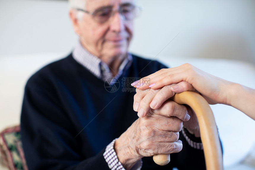 过程甘蔗由女健康访客慰藉的不快乐老年男子举手走着棍棒行水平的图片