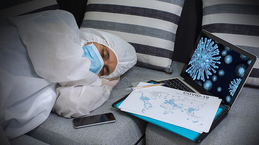 身穿防护服和口罩躺在沙发上休息的医护人员图片